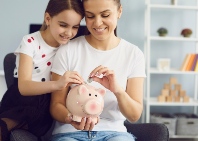Adult and child put money into piggy bank